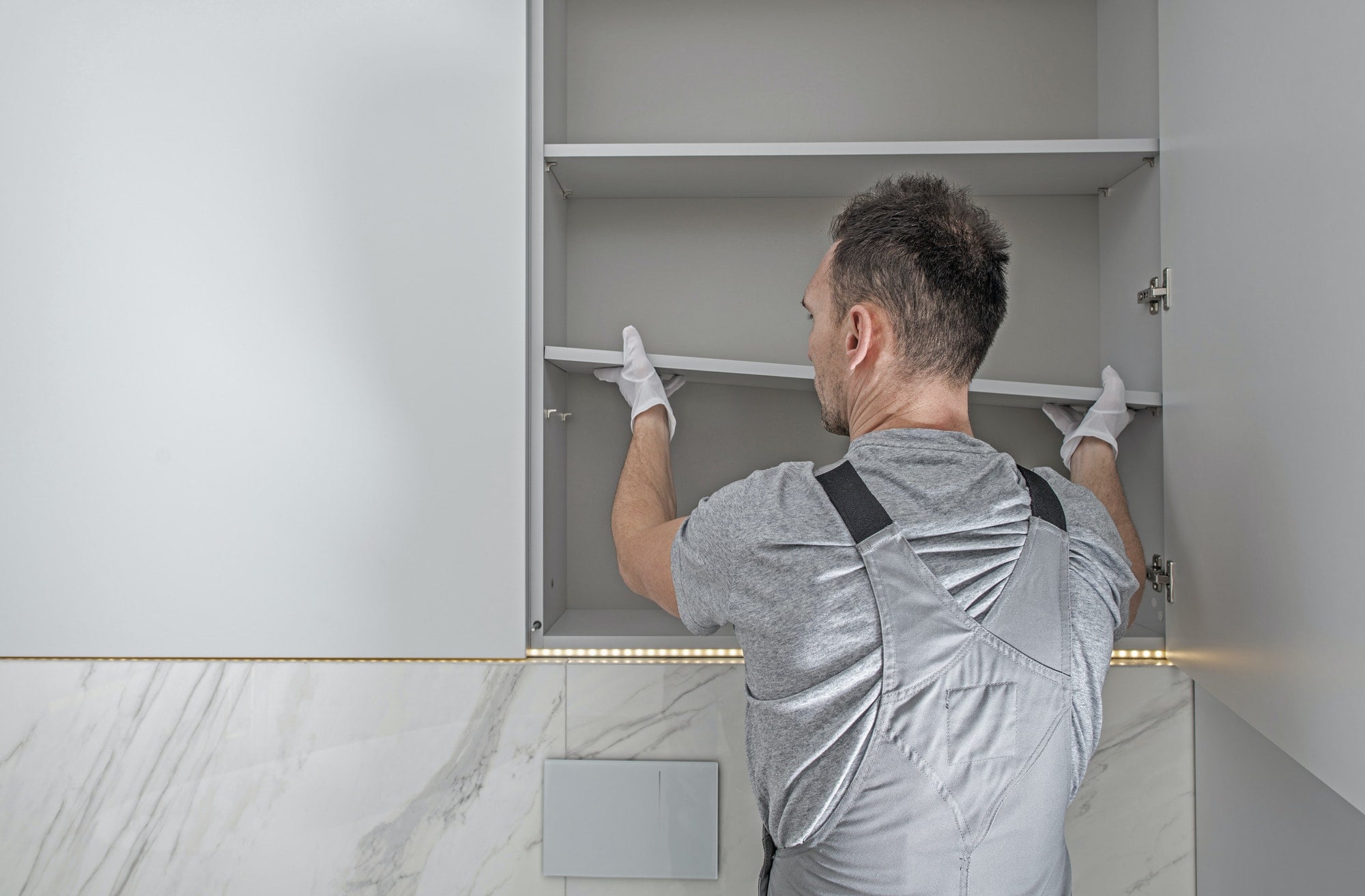 Men Installing Modern Bathroom White Cabinets